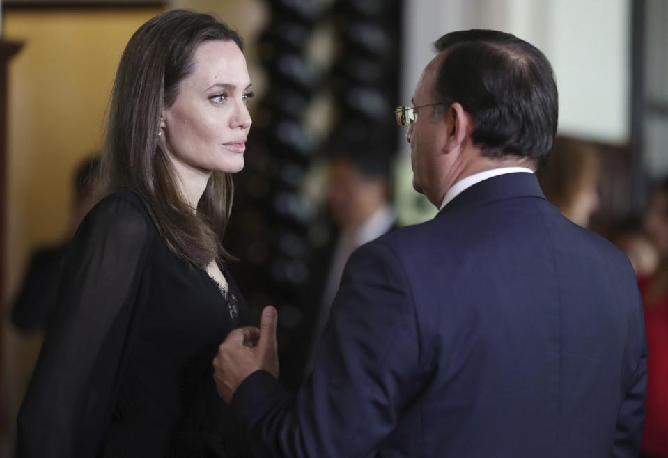 Angelina Jolie escucha al ministro de Exteriores de Perú, Néstor Popolizio, tras una conferencia de prensa en el palacio de gobierno en Lima, el martes 23 de octubre del 2018. La actriz y activista, quien se reunió con refugiados venezolanos el lunes, se encuentra en Perú como enviada especial del Alto Comisionado de Naciones Unidas para Refugiados (ACNUR). (AP Foto/Martín Mejía)