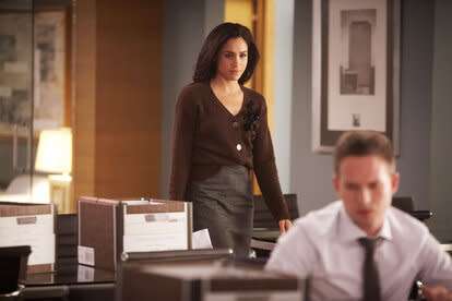 Meghan Markle wears a brown cardigan and brown skirt in an episode of 'Suits'