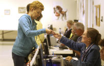 Sherry Yoksh of Cheyenne gets a voting card from Ruth Carol of Cheyenne at Yellowstone Baptist Church during the primary election Tuesday, Aug. 21, 2018, in Cheyenne, Wyo. (Jacob Byk/The Wyoming Tribune Eagle via AP)