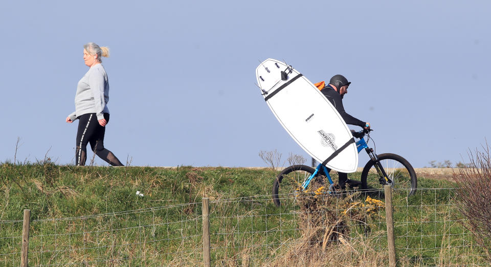 With car parks closed, surfers are finding new ways to reach the beach (Owen Humphreys/PA)