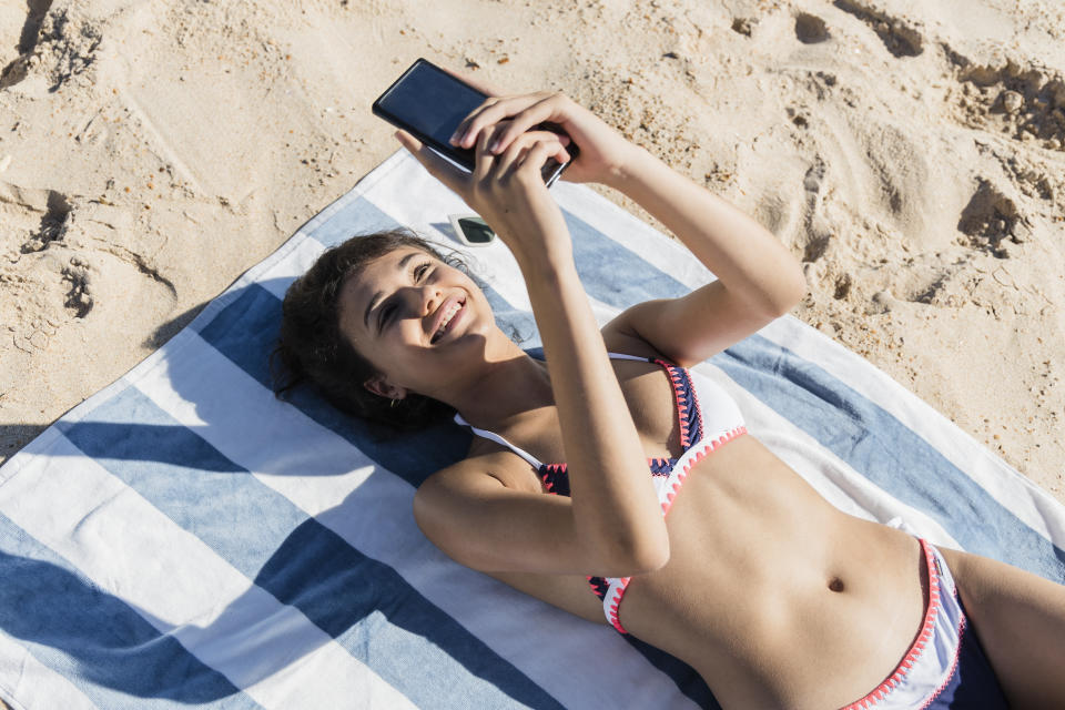 Das Handy ist im Urlaub so praktisch. Leider bieten Strandoutfits selten Platz für das Gerät. (Symbolbild: Getty Images)