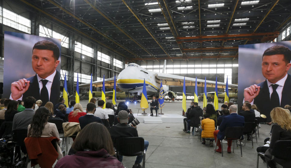 Ukrainian President Volodymyr Zelenskyy gestures while speaking to the media during a news conference with the world's largest airplane, Ukrainian Antonov An-225 Mriya in the background at the Antonov aircraft factory in Kyiv, Ukraine, Thursday, May 20, 2021. (AP Photo/Efrem Lukatsky)