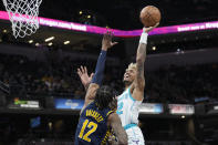 Charlotte Hornets guard Kelly Oubre Jr., right, shoots over Indiana Pacers forward Oshae Brissett during the first half of an NBA basketball game in Indianapolis, Wednesday, Jan. 26, 2022. (AP Photo/AJ Mast)