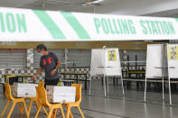 A voter casts his ballot at at the Chung Cheng High School polling center in Singapore, Friday, July 10, 2020. Wearing masks and plastic gloves, Singaporeans began voting in a general election that is expected to return Prime Minister Lee Hsien Loong's long-governing party to power. (AP Photo)