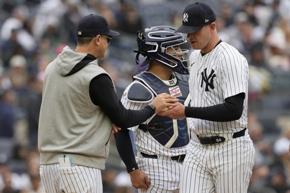 New York Yankees manager Aaron Boone, left, removes pitcher Caleb Ferguson, right, from the game in the sixth inning of a baseball game against the Detroit Tigers, Saturday, May 4, 2024, in New York. (AP Photo/Mary Altaffer)