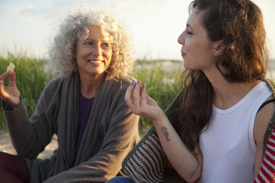 Older woman and younger woman having a picnic on a beach