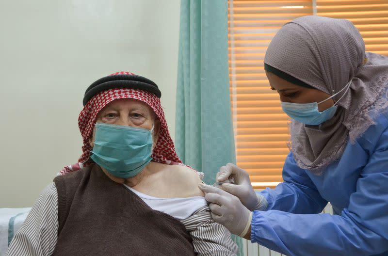 A man receives the COVID-19 vaccine, at a medical center in Amman