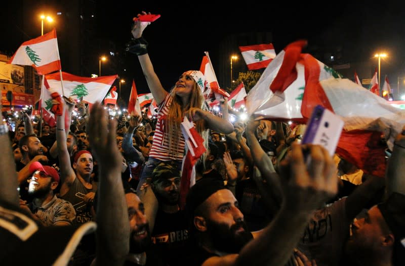 Demonstrators take pictures with their mobile phones during an anti-government protest in Tripoli