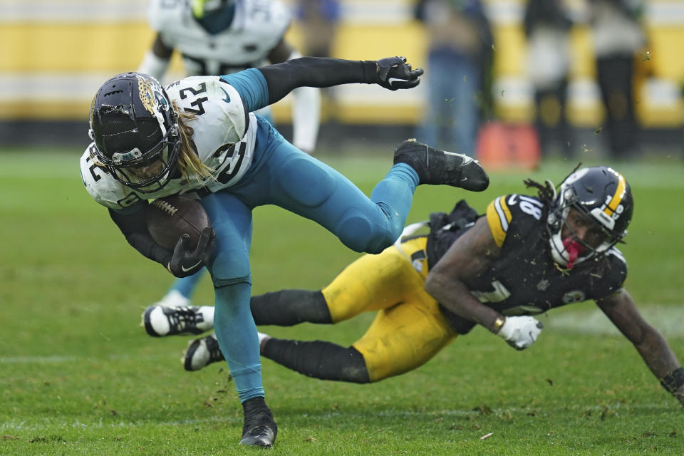 Jacksonville Jaguars safety Andrew Wingard (42) stumbles after intercepting a pass in front of Pittsburgh Steelers wide receiver Diontae Johnson (18) during the second half of an NFL football game Sunday, Oct. 29, 2023, in Pittsburgh. (AP Photo/Matt Freed)