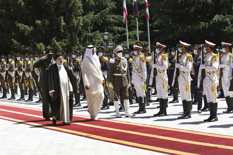 In this photo released by the official website of the office of the Iranian Presidency, Qatari Emir Sheikh Tamim bin Hamad Al Thani, second left, reviews an honor guard as he is welcomed by President Ebrahim Raisi, left, during an official arrival ceremony at the Saadabad Palace in Tehran, Iran, Thursday, May 12, 2022. Qatar's emir arrived in Tehran for talks with the Iranian president as efforts to save Tehran's tattered nuclear deal with world powers hit a deadlock. (Iranian Presidency Office via AP)