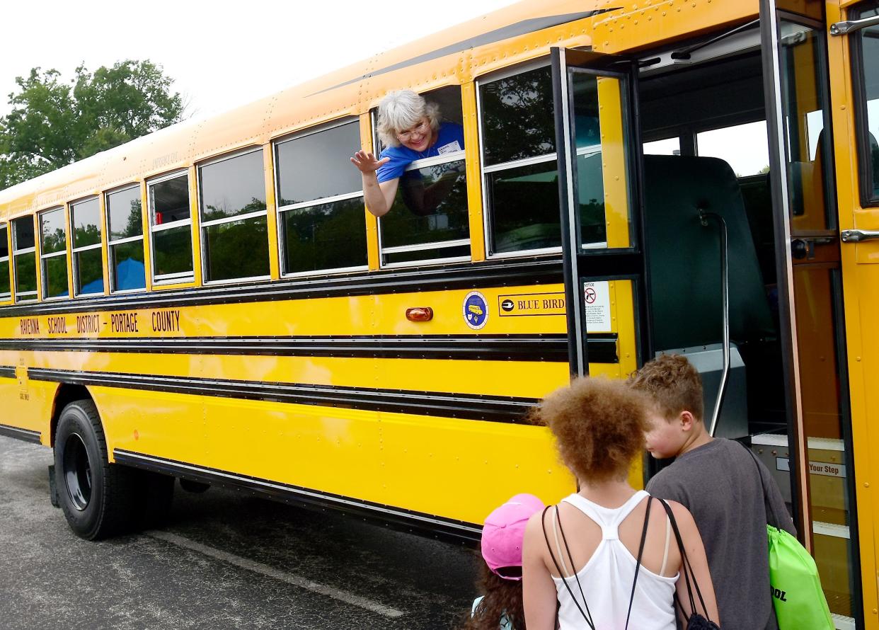 Joyce Torres, who was a bus driver with the Ravenna school district, waves from the window of the new bus at Ravenna High School during the Ravenna Back to School Bash in 2018 in this Record-Courier file photo. This school year, the district is making changes to its busing.