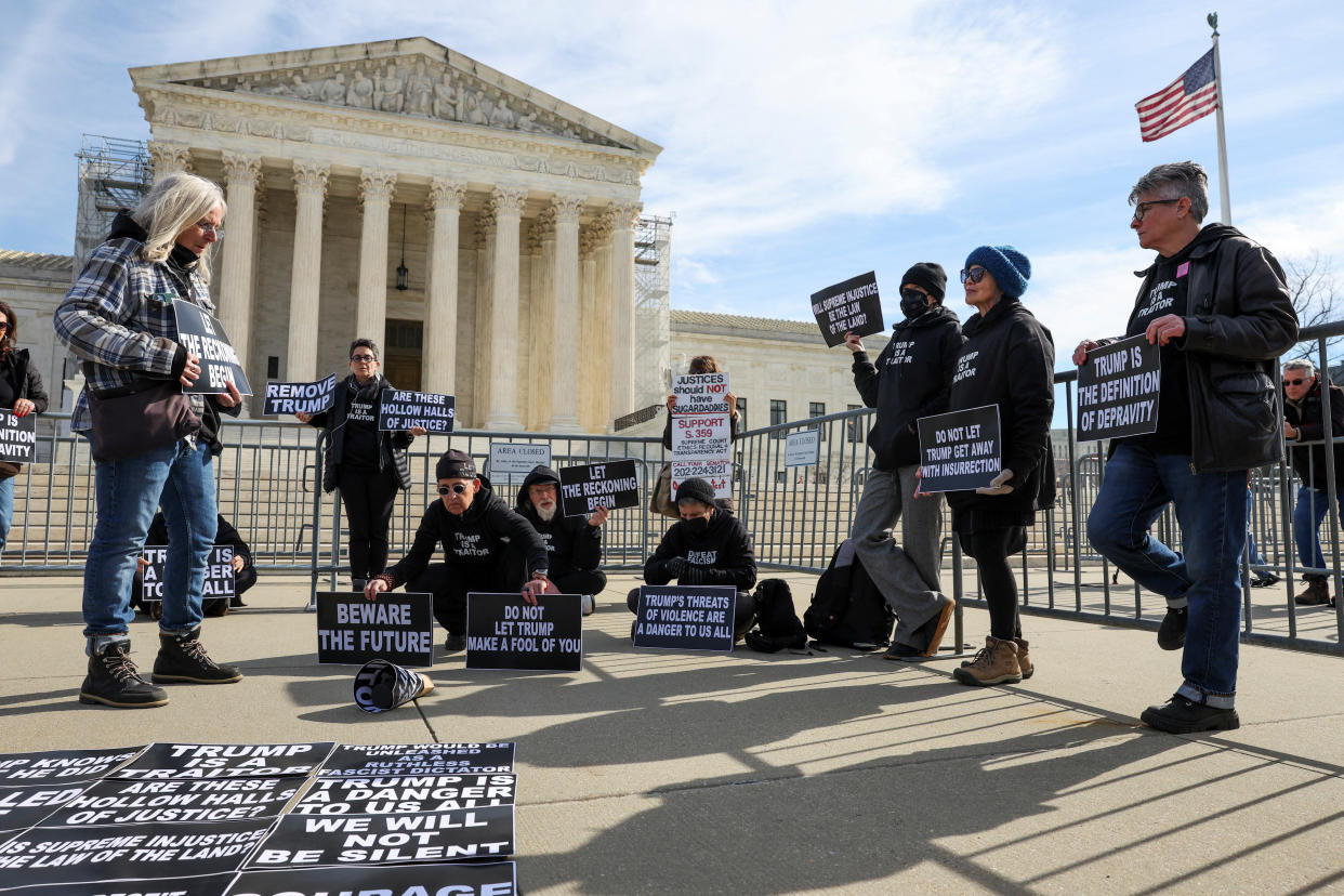 Activists listen to proceedings outside the U.S. Supreme Court 