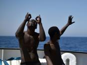 Migrants react after being rescued by the crew of MS Aquarius off the Libyan coast