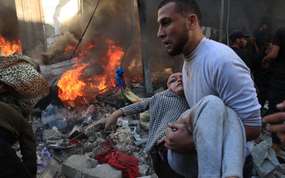 A man evacuates a wounded girl after Israeli bombardment in Rafah in the southern Gaza Strip