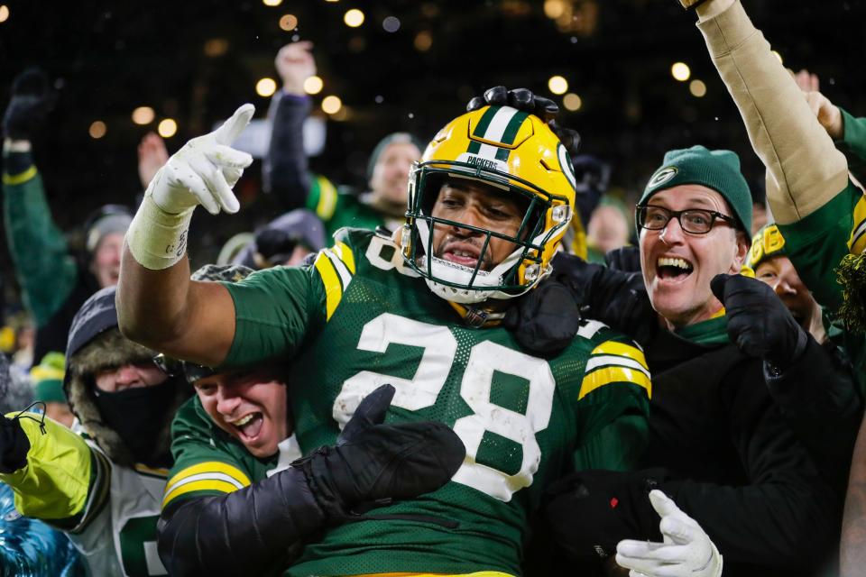 Green Bay Packers' AJ Dillon celebrates with fans after rushing for a touchdown during a 2021 game at Lambeau Field. Green Bay police say their internal affairs department concluded a review after a video on social media showed an officer grabbing the Packers running back during the July 23 international soccer match at Lambeau Field.