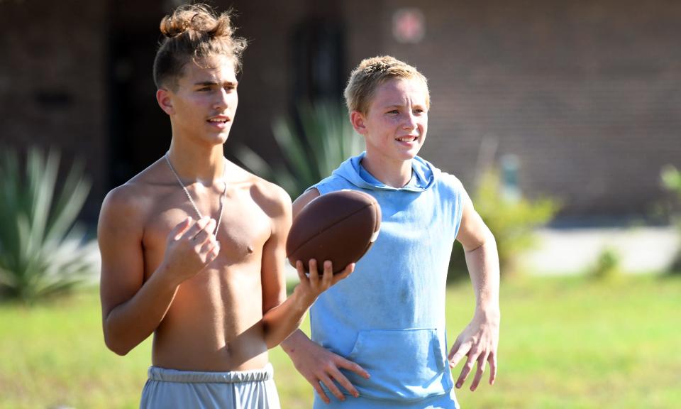 Two of the teens at football practice. Malyk Steward, 24, an athletic trainer, gives his time and talents after work to help train kids in football at Americas Best Value Inn, located on A1A in South Patrick Shores. The kids call him "Coach Malyk."