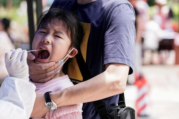 Una niña reacciona mientras se somete a un test de ácido nucleico en Wuhan, China.