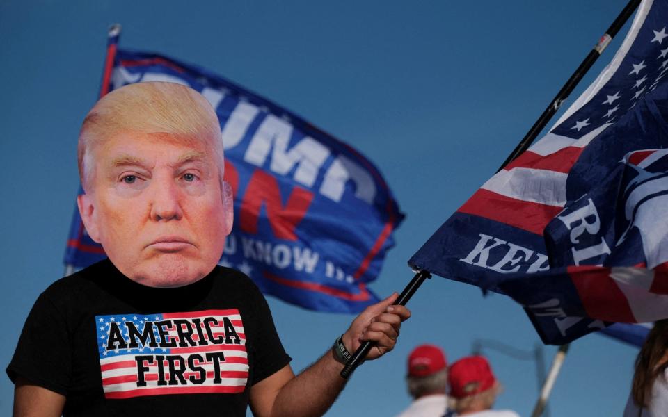 A supporter of the former president attending a gathering outside his Mar-a-Lago resort - RICARDO ARDUENGO