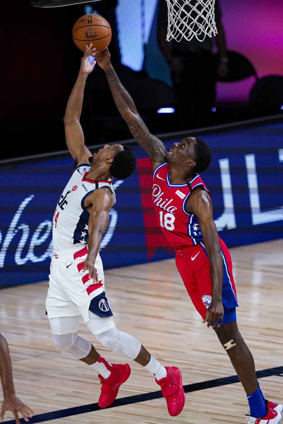 Washington Wizards guard Ish Smith (14) has his shot blocked by Philadelphia 76ers guard Shake Milton (18) during the second half of an NBA basketball game Wednesday, Aug. 5, 2020 in Lake Buena Vista, Fla. (AP Photo/Ashley Landis)