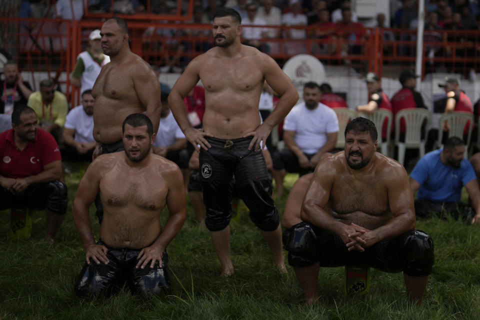 Wrestlers rest waiting for their turn to wrestle during the 663rd annual Historic Kirkpinar Oil Wrestling championship, in Edirne, northwestern Turkey, Saturday, July 6, 2024. Wrestlers take part in this "sudden death"-style traditional competition wearing only a pair of leather trousers and a good slick of olive oil. The festival is part of UNESCO's List of Intangible Cultural Heritages. (AP Photo/Khalil Hamra)
