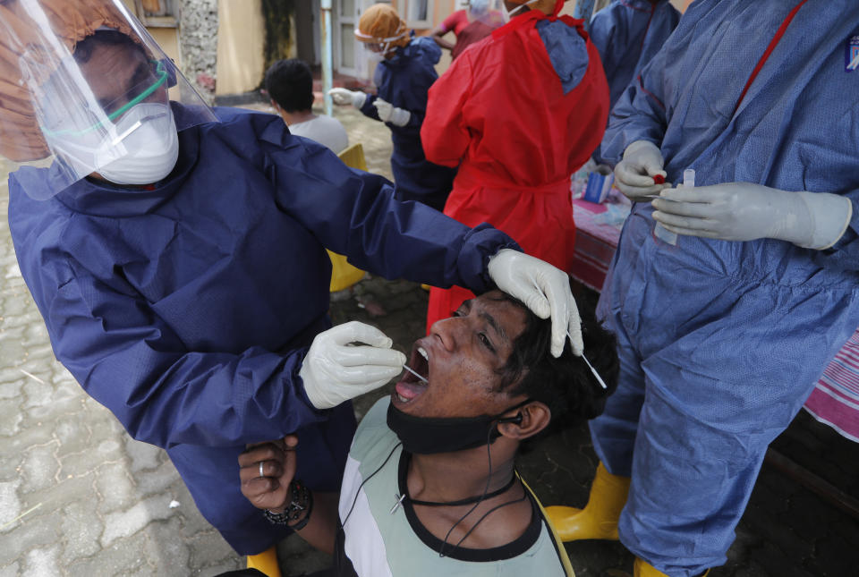 Sri Lankan municipal health workers collect a swab sample from a drug addict to test for COVID-19 in Colombo, Sri Lanka, Friday, Sept. 11, 2020. (AP Photo/Eranga Jayawardena)