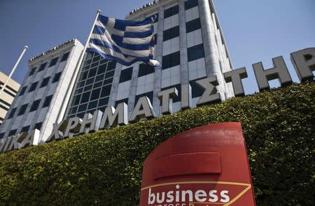 A Greek flag flutters outside the Athens stock exchange , Greece, July 27, 2015. REUTERS/Ronen Zvulun