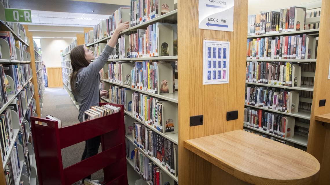 Library page Morgan Williams returns books to their shelves at the Meridian Library on Cherry Lane.