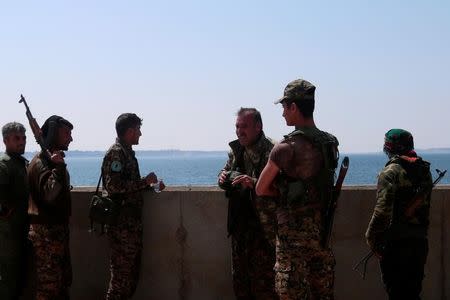 FILE PHOTO: Syrian Democratic Forces (SDF) fighters stand at the northern part of the Tabqa Dam on the Euphrates River, Syria March 28, 2017. REUTERS/Rodi Said