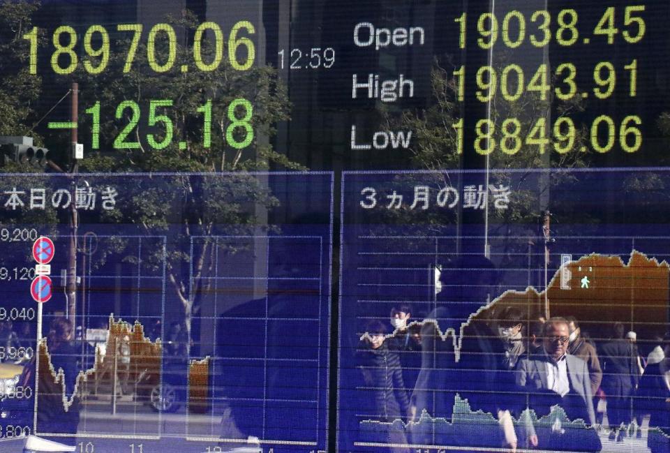 People are reflected on an electronic stock indicator of a securities firm in Tokyo, Tuesday, Jan. 17, 2017. Asian stocks declined Tuesday after Britain said Prime Minister Theresa May will announce London's plans to withdraw completely from the European Union. (AP Photo/Shizuo Kambayashi)