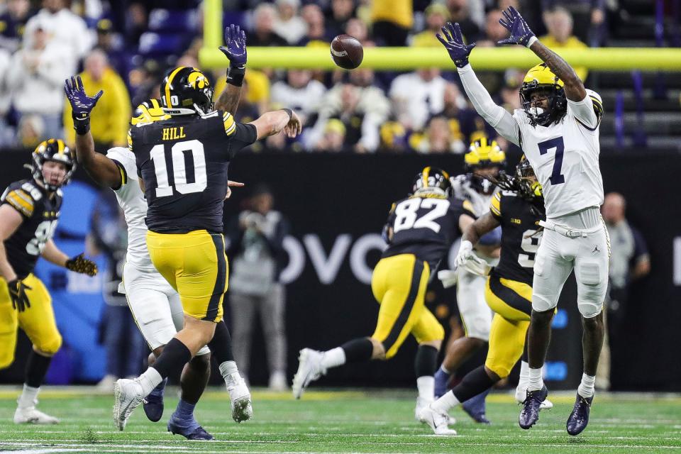 Michigan defensive back Makari Paige (7) tries to block a pass from Iowa quarterback Deacon Hill during the first half of the Big Ten championship game at Lucas Oil Stadium in Indianapolis, Ind. on Saturday, Dec. 2, 2023.