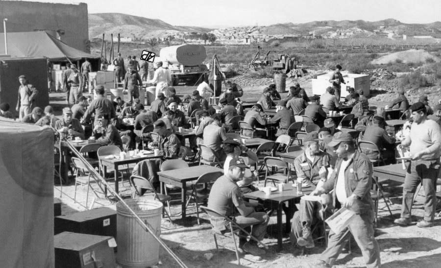 Open air luncheon at Camp Wilson in Palomares Beach, Spain on Feb. 17, 1966. Nuclear search teams have noon-day meal from field kitchen. Two at right appear well fed. (AP Photo)
