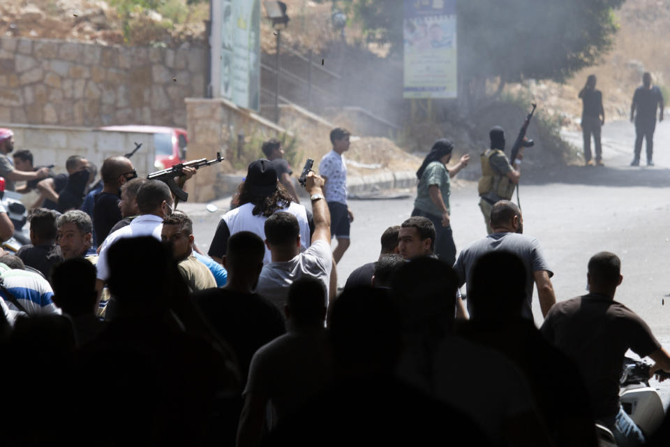 Sunni gunmen open fire on a building during the funeral procession of Hassan Zaher Ghosn, 14, who was killed last night, in Khaldeh, south of Beirut, Lebanon, Friday, Aug. 28, 2020. Clashes broke out last night between rival groups at the southern entrance of the Lebanese capital leaving two people dead and three wounded, state-run National News Agency reported. (AP Photo/Hassan Ammar)