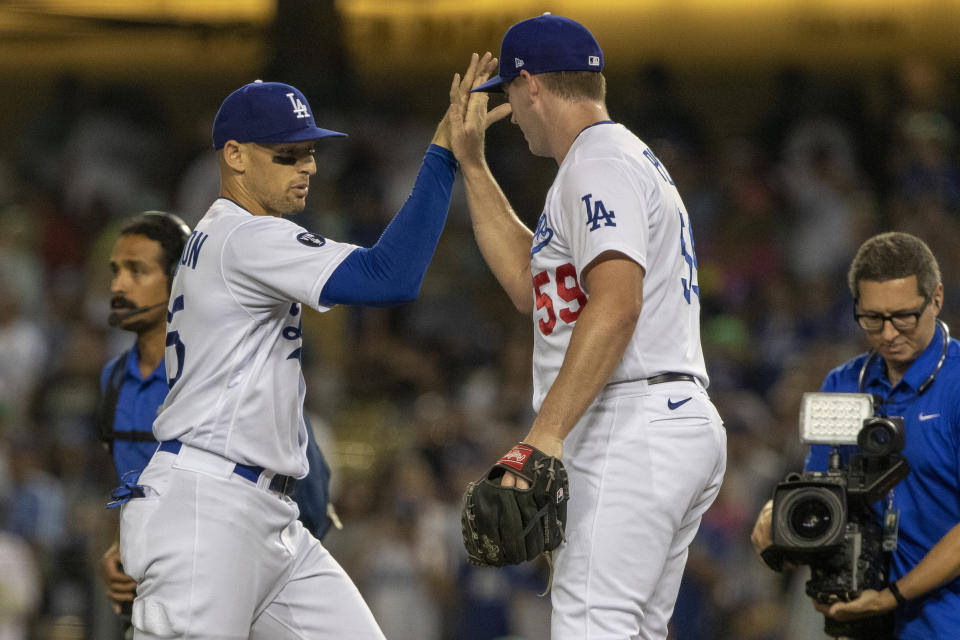 Los Angeles Dodgers relief pitcher Evan Phillips, right, celebrates with center fielder Trayce Thompson, left, after the team's baseball game against the Miami Marlins in Los Angeles, Friday, Aug. 19, 2022. The Dodgers won 2-1. (AP Photo/Alex Gallardo)