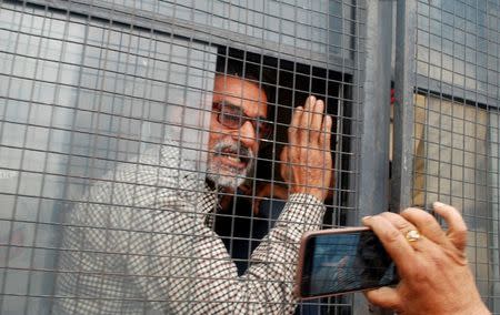 Sanji Ram gestures from a police vehicle as he arrives for a court appearance in connection with the rape and murder of an eight-year-old girl in Kathua, south of Jammu, April 16, 2018. REUTERS/Stringer