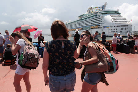 Women react as people line up to board a Royal Caribbean cruise ship that will take them to the U.S. mainland, in San Juan, Puerto Rico September 28, 2017. REUTERS/Alvin Baez