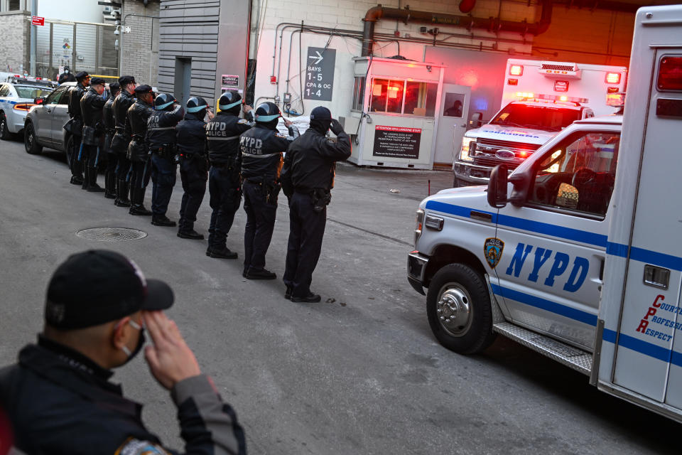 NYPD officers line up and salute as the body of Officer Wilbert Mora is transferred in an ambulance from NYU Langone Hospital to a Medical Examiner's office at the same location on January 25, 2022 in New York City. Officer Mora was critically injured after responding to a domestic violence call on January 21, where his partner, 22-year-old Officer Jason Rivera was shot and killed. / Credit: / Getty Images