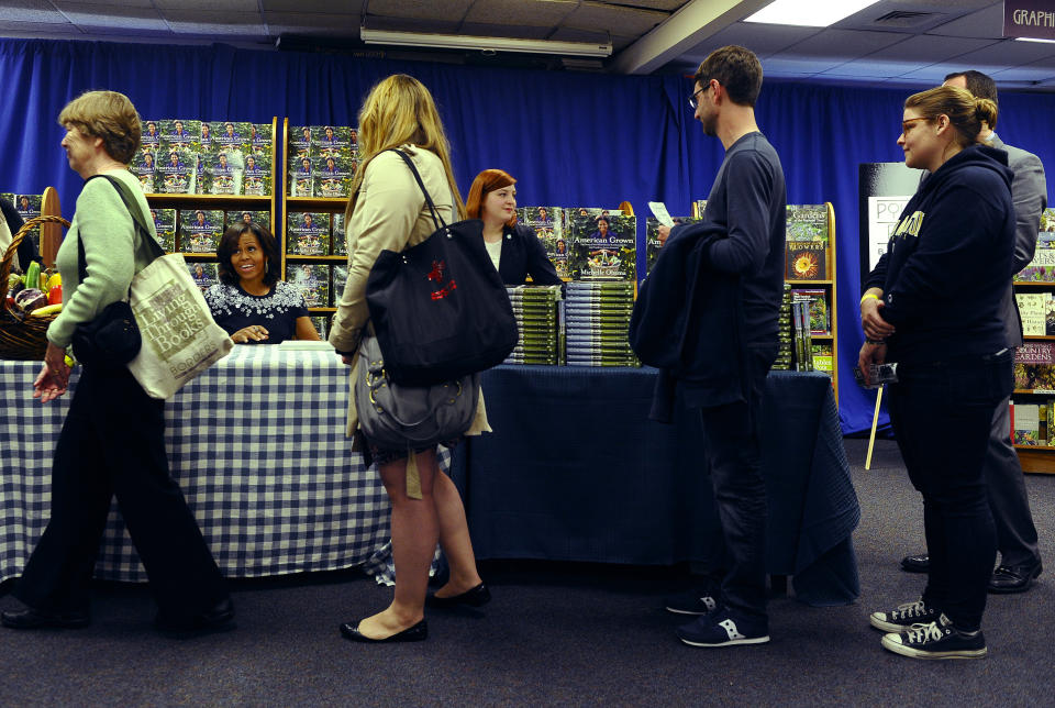 US First Lady Michelle Obama signs a copy of her book 'American Grown: The Story of the White House Kitchen Garden and Gardens Across America,' during a book signing event at Politics & Prose in Washington, DC, on May 7, 2013. Photo credit:  JEWEL SAMAD/AFP/Getty Images