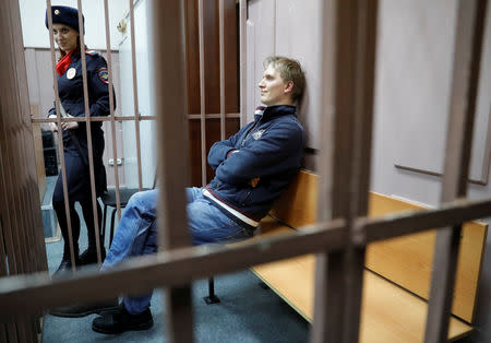 Investment Director of the Baring Vostok private equity group Ivan Zyuzin, who was detained on suspicion of embezzlement, sits inside a defendants' cage as he attends a court hearing in Moscow, Russia February 15, 2019. REUTERS/Tatyana Makeyeva