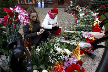 Women light candles to commemorate victims of the Paris attacks, in front of the French embassy in Minsk, Belarus November 16, 2015. REUTERS/Vasily Fedosenko