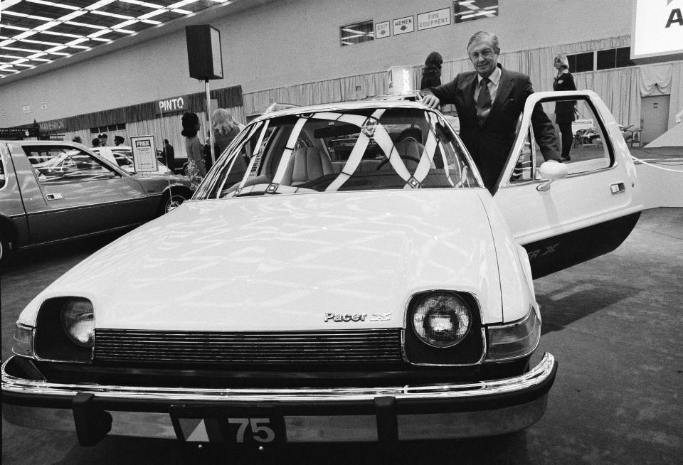 FILE - In this Jan. 12, 1975, file photo, American Motors' board chairman Roy D. Chapin checks over the company's new sub-compact Pacer during a preview ceremony at the 1975 Detroit Auto Show. Show organizers expect more than 50 new model introductions when the 2014 show kicks off Monday Jan. 13, 2014. (AP Photo/File)