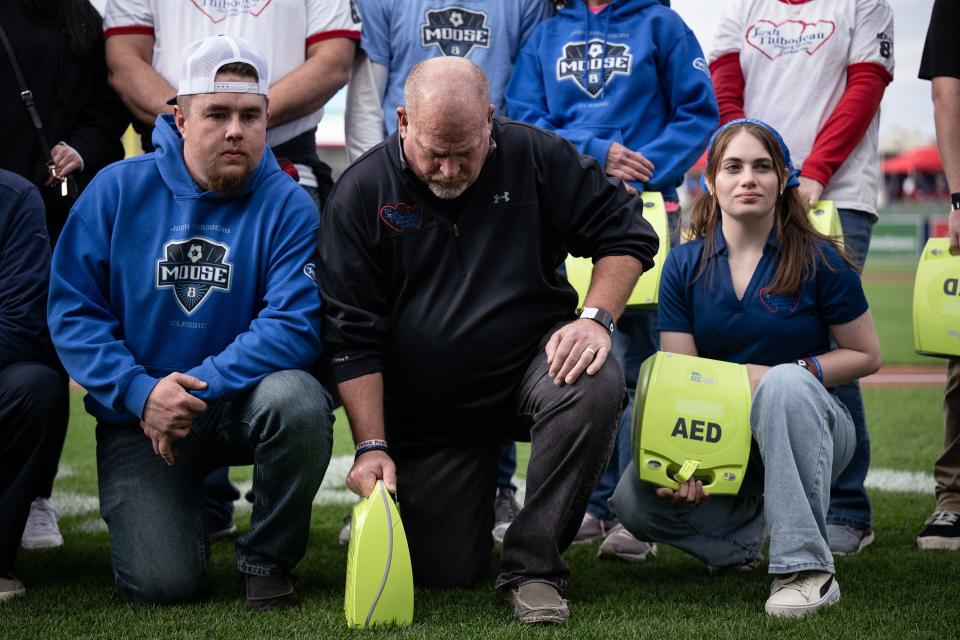 Local Little leagues are gifted automated external defibrillator machines at Polar Park on Friday. Ralph Thibodeau, center, hangs his head as he tragically lost his son Josh to cardiac arrest during a soccer camp in 2011.