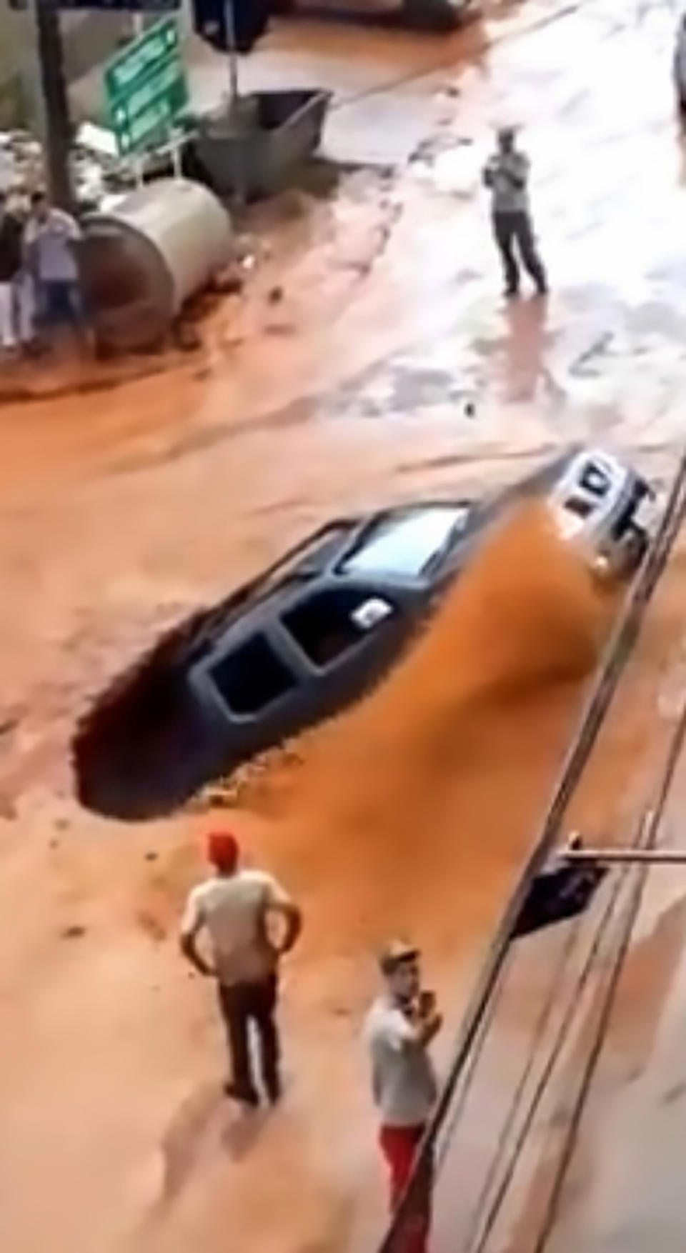 Rainwater gushed into the hole leaving the two people inside the vehicle terrified. Source: CEN/ Australscope