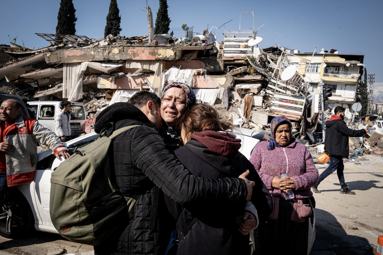 Weeping survivors in front of destroyed buildings in Hatay.