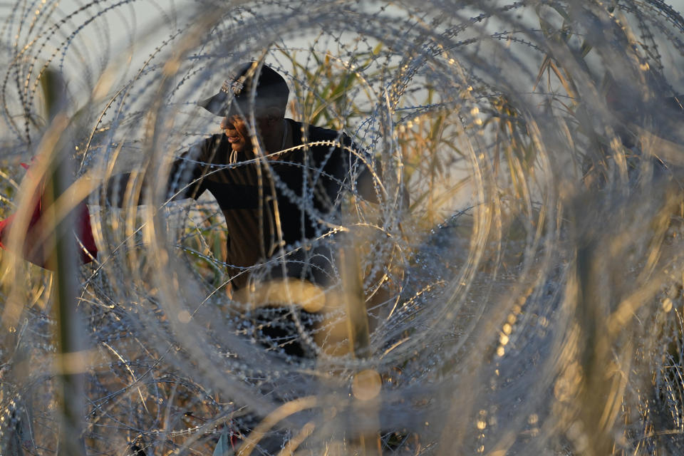 Migrants climb over concertina wire after they crossed the Rio Grande and entered the U.S. from Mexico, Saturday, Sept. 23, 2023, in Eagle Pass, Texas. (AP Photo/Eric Gay)