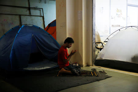 A migrant prays inside the disused Hellenikon airport, where refugees and migrants are temporarily housed, in Athens, Greece, July 13, 2016. REUTERS/Alkis Konstantinidis/File Photo