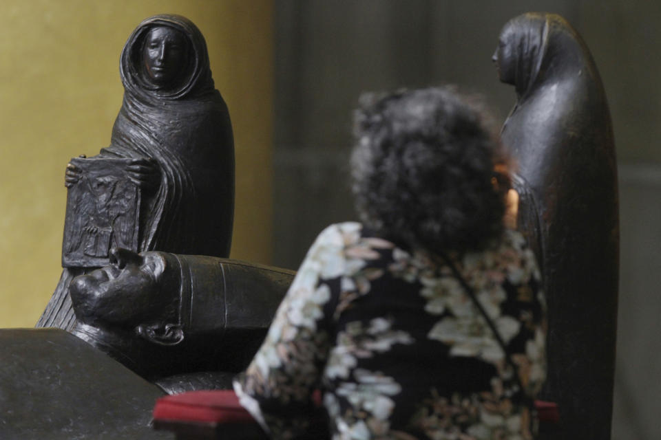 A woman kneels at the tomb of Archbishop Oscar Romero inside the Metropolitan Cathedral in Sann Salvador, El Salvador, Sunday, April 7, 2019. California Gov. Gavin Newsom visited the tomb of Archbishop Romero, the Salvadoran priest assassinated in 1980 due to his advocacy for human rights and the poor. (AP Photo/Salvador Melendez, Pool)