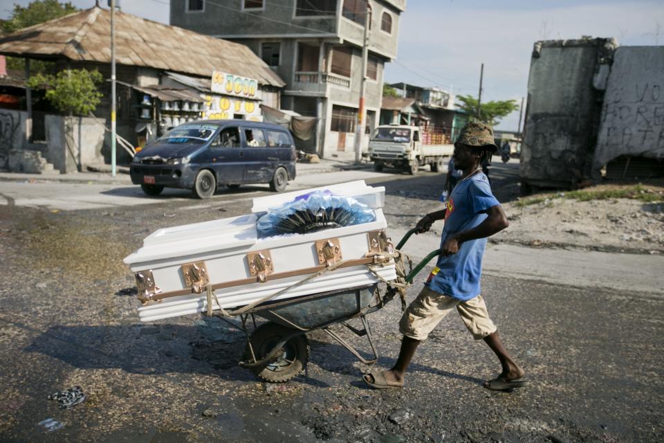 A worker delivers a coffin uses a wheelbarrow to a private morgue in Port-au-Prince, Haiti, Thursday, March 21, 2019. (AP Photo/Dieu Nalio Chery)