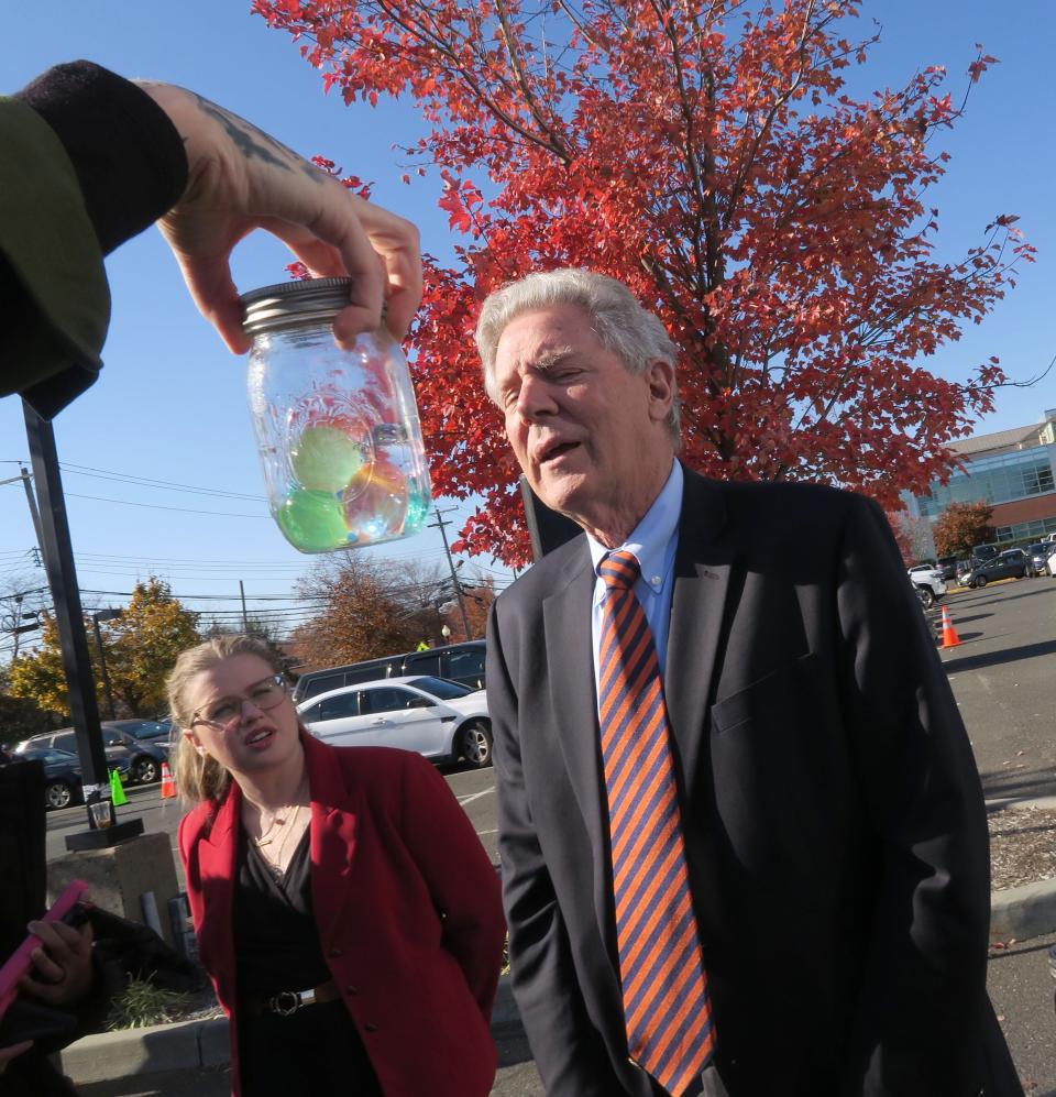 Congressman Frank Pallone (D-NJ) looks over to a jar containing water beads during a Monday, November 13, 2023, press conference outside Jersey Shore University Medical Center in Neptune, NJ. He is planning to introduce legislation to ban that product that are marketed for kids. Shown at left is Taylor Bethard, who lost her daughter Esther to ingesting water beads.