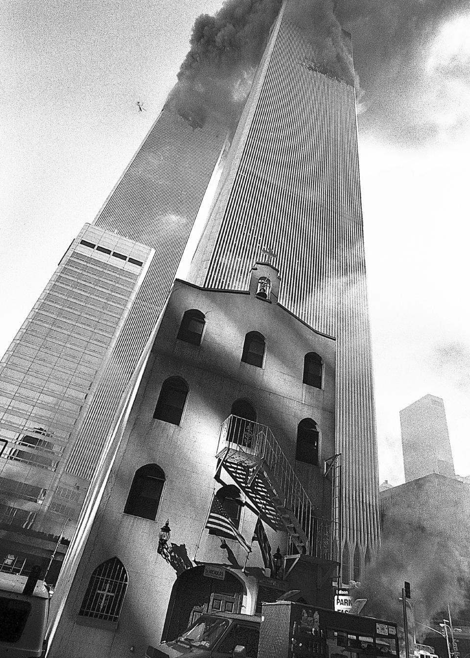 In this Sept. 11, 2001, photo provided by the Greek Orthodox Archdiocese of America, smoke billows from the World Trade Center towers as St. Nicholas Greek Orthodox Church sits below them in New York's Financial District. After a rebuilding process that lasted more than two decades, the Greek Orthodox church that was destroyed in the Sept. 11 attacks has reopened at the World Trade Center site. The St. Nicholas Greek Orthodox Church and National Shrine, designed by architect Santiago Calatrava, now overlooks the Trade Center memorial pools from an elevated park. (Greek Orthodox Archdiocese of America via AP)