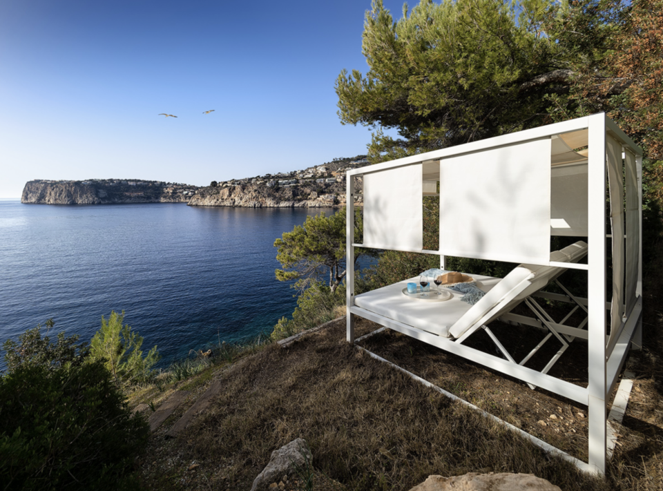 La imagen muestra el 'escondite secreto' de la vivienda. Una gran cama a solo unos metros de las aguas cristalinas del Mediterráneo, escondida entre la maleza y las rocas del acantilado. Foto: cortesía de Engel & Voelkers Mallorca.